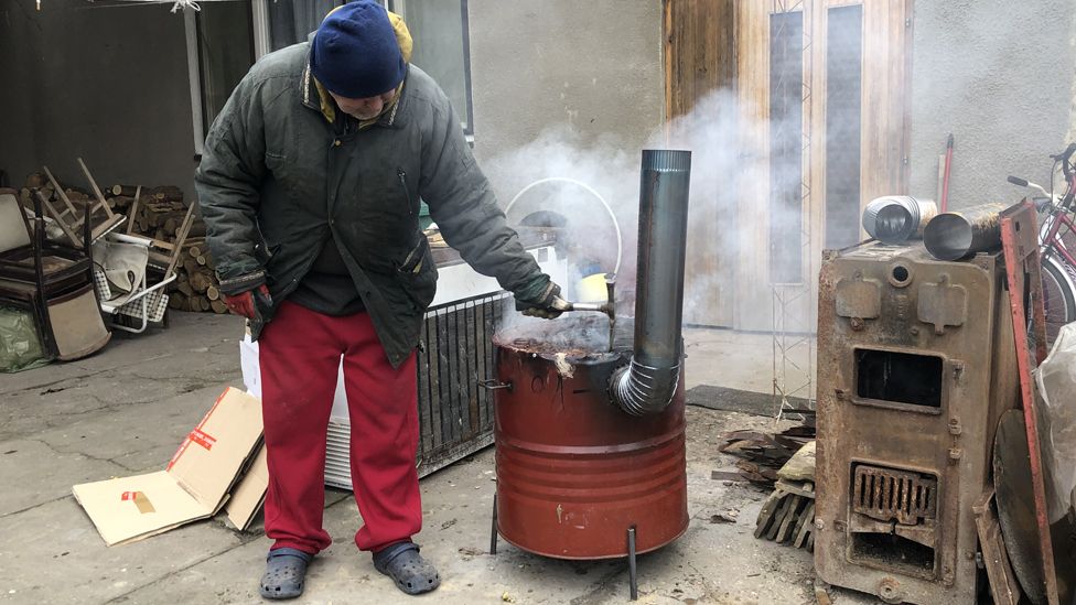 Pastor Tibor Varga with basic barrel stove for migrants