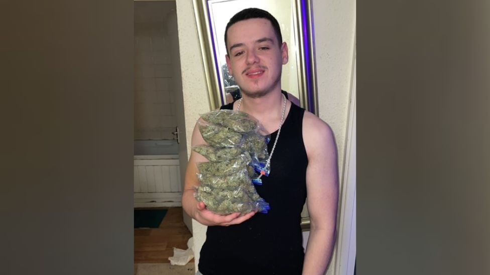 Elijah Clark holding bags of cannabis