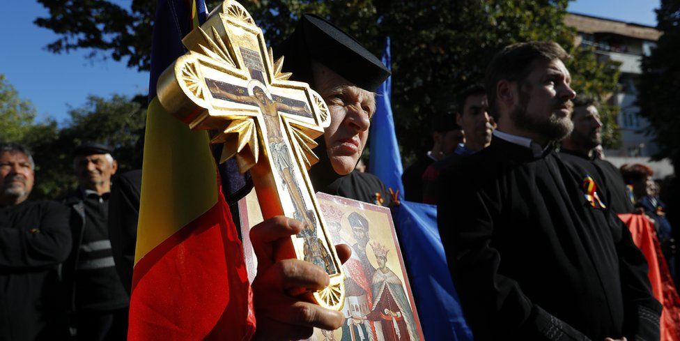 A Romanian Orthodox nun holds a cross, a national flag and an icon during a support rally for the family re-definition referendum planned for this weekend, in the small city of Draganesti Olt, 260 kilometers south-east from Bucharest, Romania, 04 October 2018.