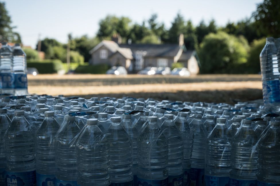 Bottles of water are stacked on the village green following a loss of domestic water supply on 10 August 2022 in the village of Northend near Henley-on-Thames, England.