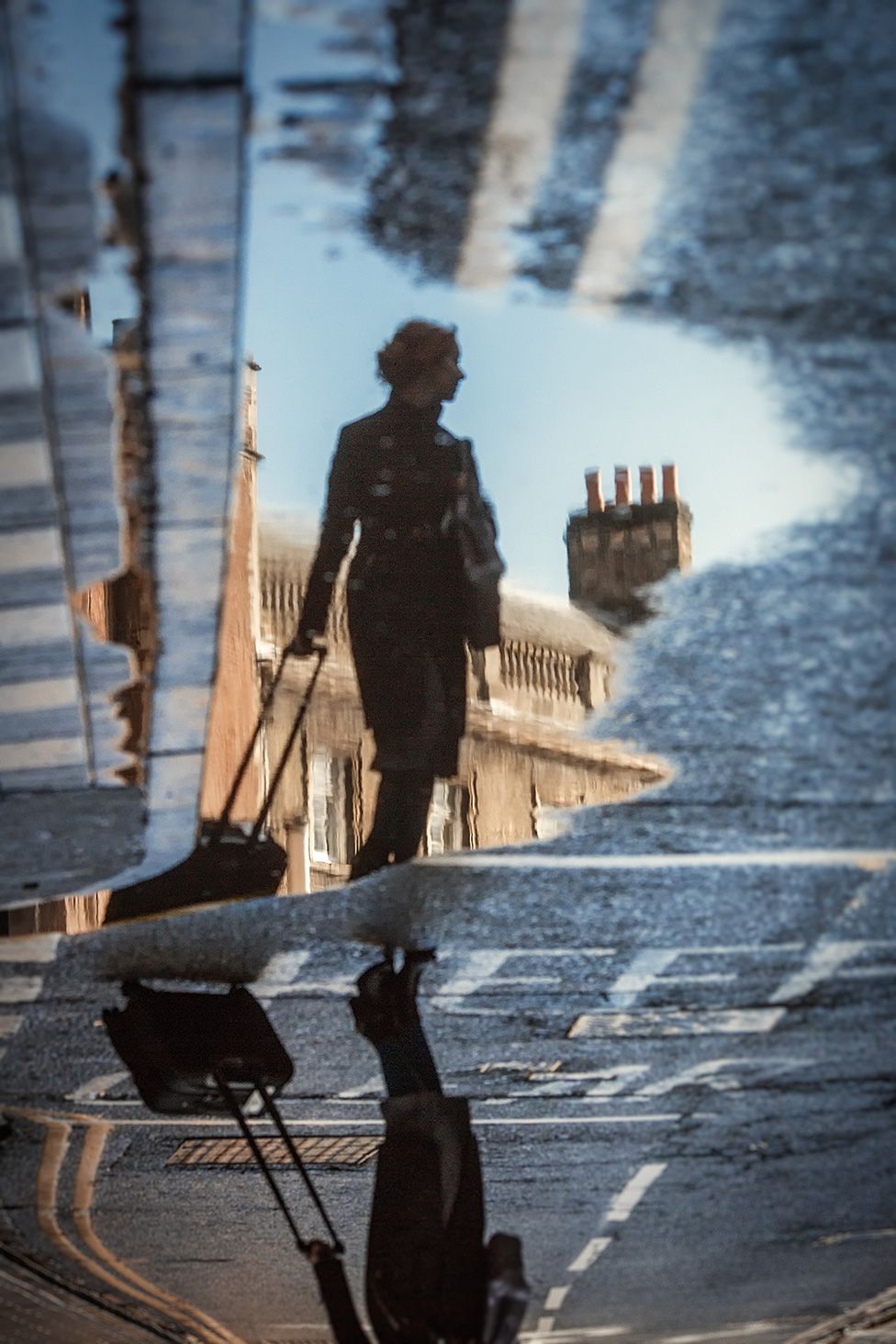 Reflection of a lady in a puddle