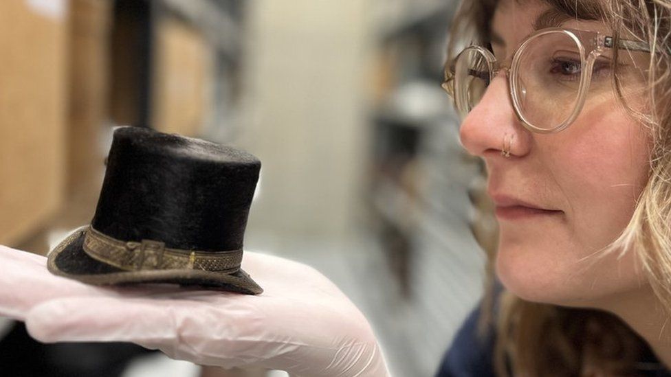 Curator with tiny top hat