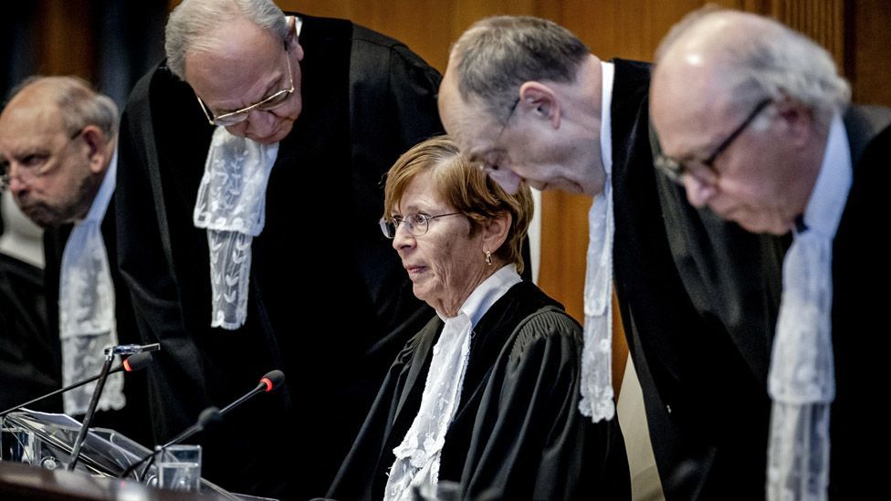 ICJ president Joan Donoghue (C) and other ICJ judges at the International Court of Justice wearing white shirts and black gowns  