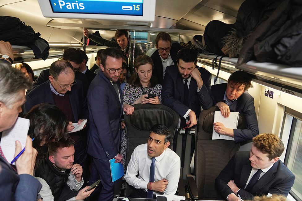 Rishi Sunak talks to the media in a train during his travelling to France