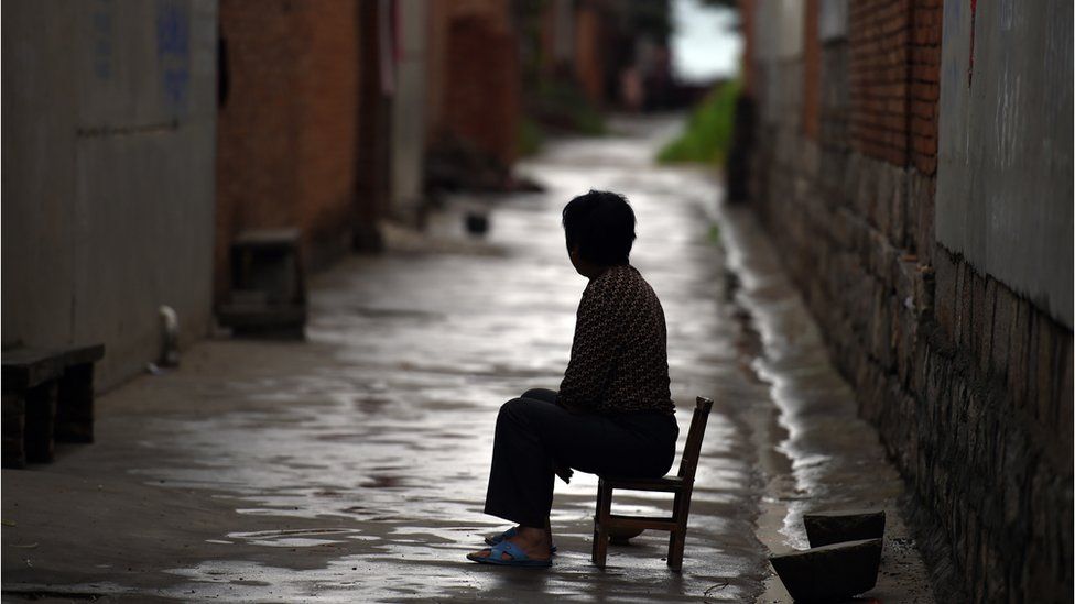 A woman sits in an alleyway in Weijian, Jenan province, China (file image)