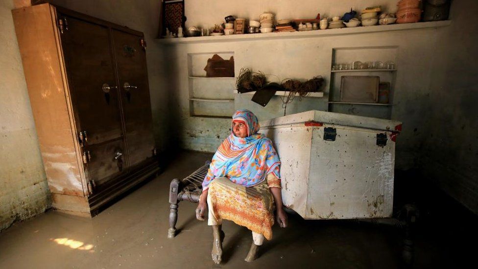 A woman stands inside her house in the aftermath of floods in Charsadda District, Khyber Pakhtunkhwa province, Pakistan, 28 August 2022.