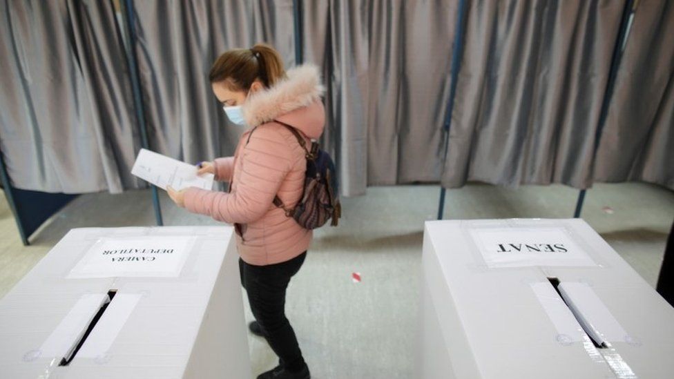 A woman prepares to cast her ballot for the legislative election in Bucharest