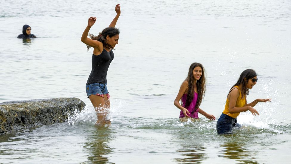 Girls cool off in the Mediterranean sea waters at a beach off La Goulette, Tunisia - Tuesday 10 August 2021