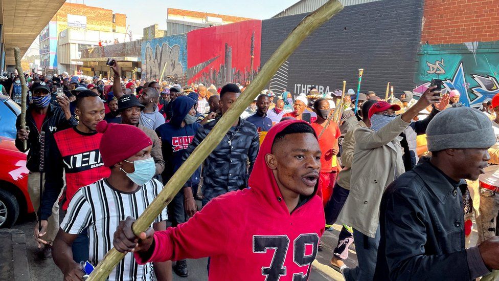 Stick-wielding protesters march through the streets as violence following the jailing of former South African President Jacob Zuma spread to the country"s main economic hub in Johannesburg, South Africa, July 11, 2021.