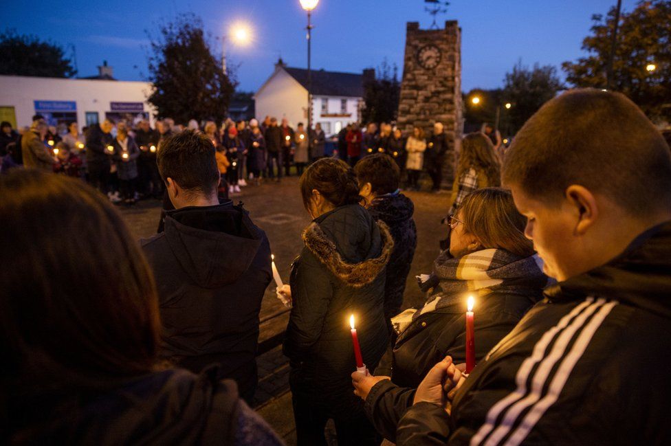 People hold candles during a vigil to remember the Creeslough disaster victims in Castlefin