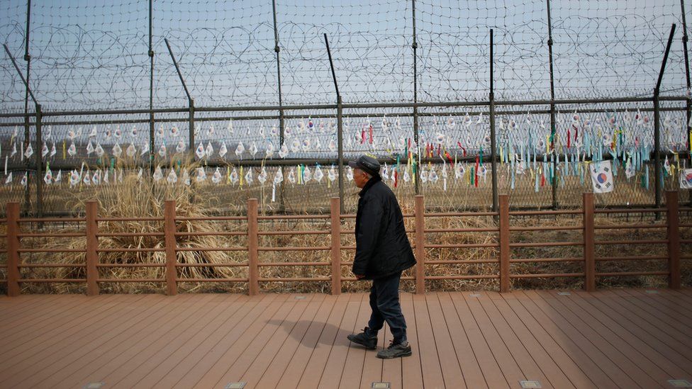A man looks at the military wire fences attached with South Korean national flags at the Imjingak Pavilion near the border with North Korea, in Paju, South Korea, Friday, March 18, 2016.