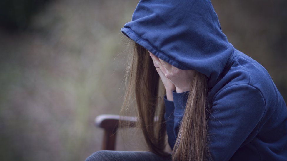 A teenage girl in a hooded top