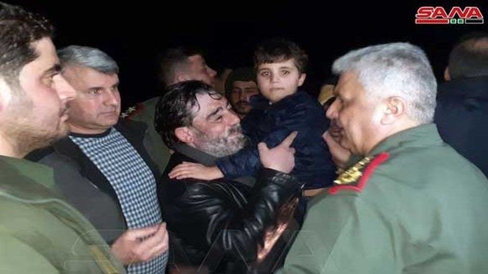 Screengrab of video from Syria's Sana news agency showing Fawaz al-Qataifan being carried by his father after kidnappers released the boy on 12 February 2022