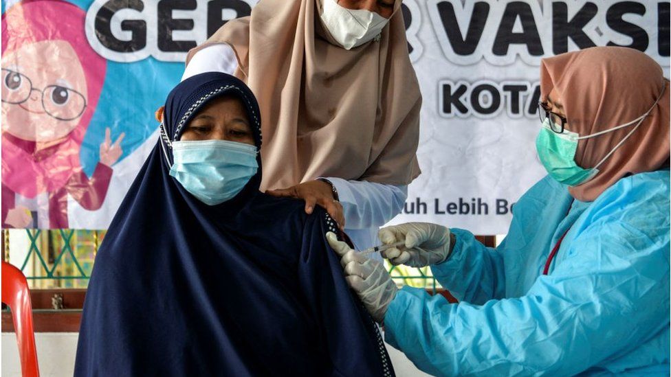 A woman receives the Sinovac vaccine at a community centre in Banda Aceh