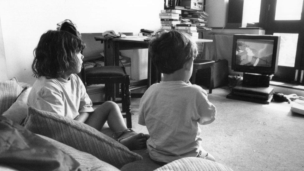 Dos niños viendo Tom y Jerry en la TV