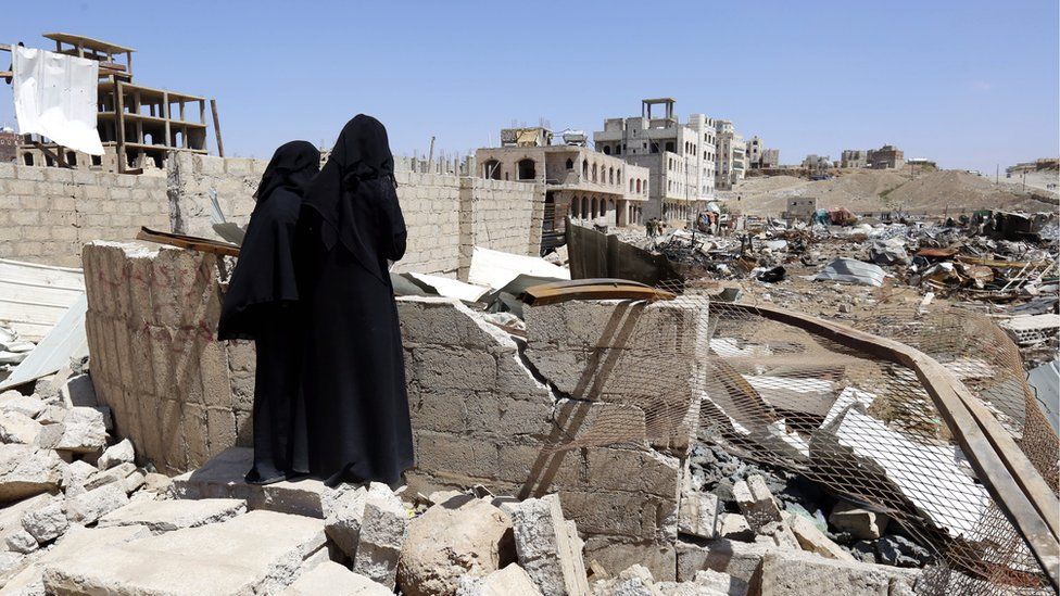 Two Yemeni women inspect the site of an alleged Saudi-led airstrike hit a neighbourhood two days earlier, damaging nearby schools, in Sanaa