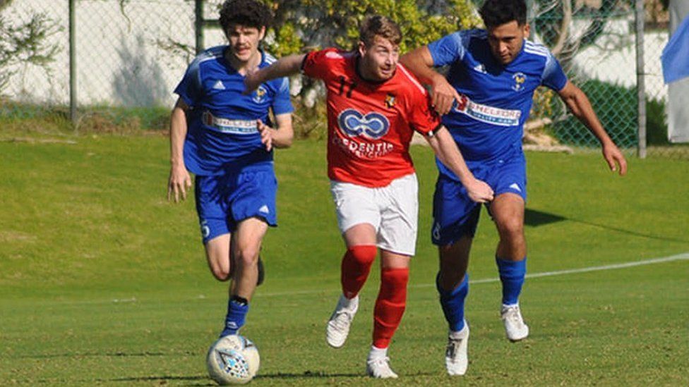 Danny Hodgson challenges for a ball (centre in red shirt)