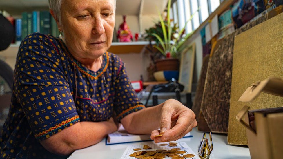 Dr Gabriela Bijovsky examining the coins