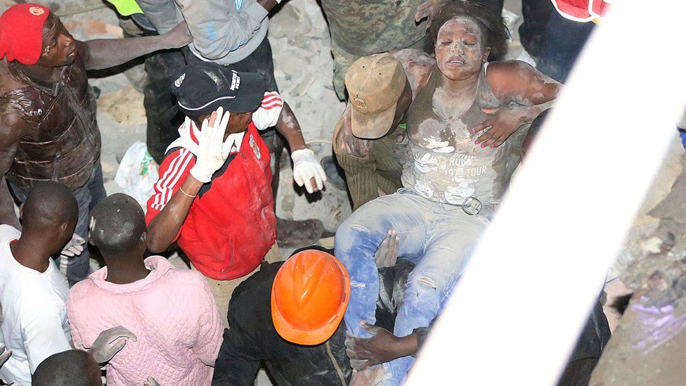 Emergency personnel rescue a woman from a collpased building in Nairobi late on April 29, 2016.