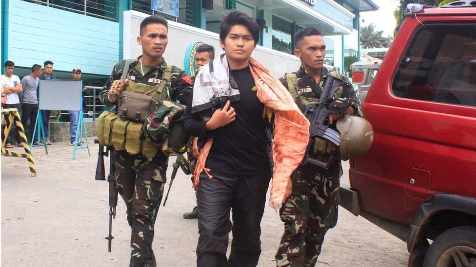 This photo taken on August 23, 2016 shows Philippine soldiers escorting Maute extremist group member Hassim Balawag Maute alias Apple Jehad to a military vehicle in Marawi City in the southern island of Mindanao