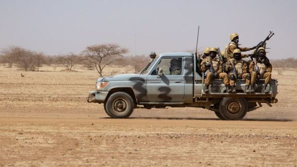 Burkina Faso soldiers patrol aboard a pick-up truck on the road from Dori to the Goudebo refugee camp, on February 3, 2020