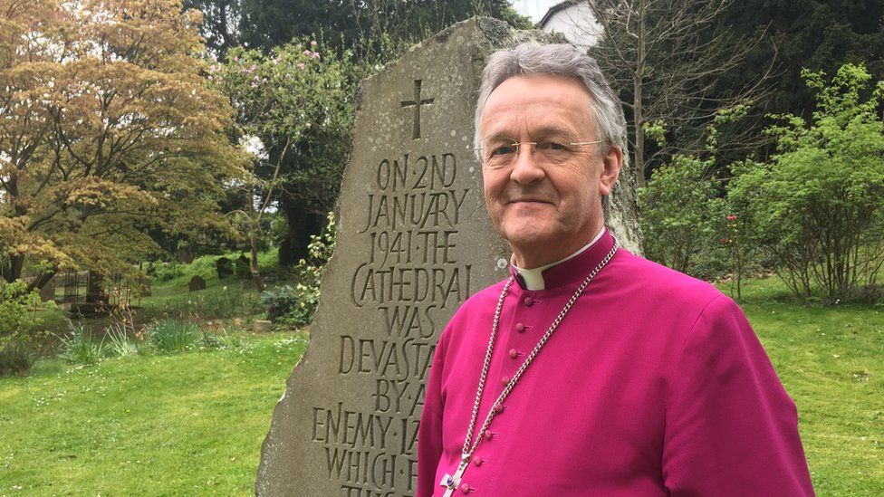 Bishop John at Llandaff Cathedral next to the stone marking the stop where a bomb devastated the Cathedral during World War Two