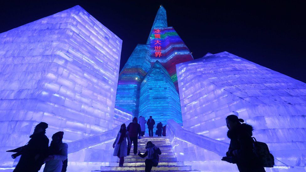 People visit the ice sculptures illuminated by coloured lights at Harbin ice and snow world for the 33rd Harbin International Ice and Snow Festival in Harbin city, China's northern Heilongjiang province, 05 January 2017.