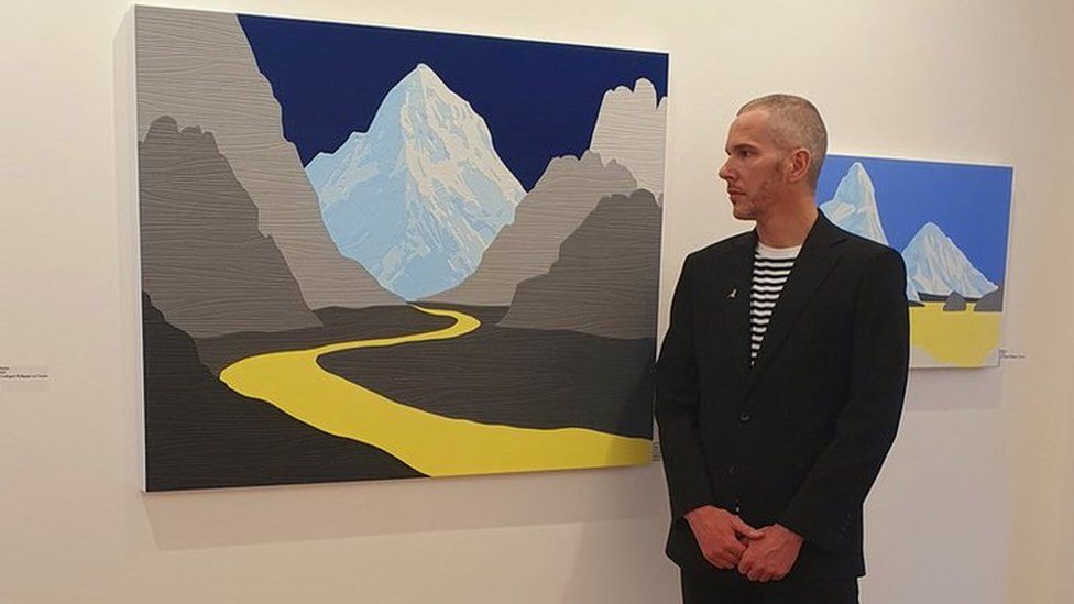 David Wightman stood beside his artworks