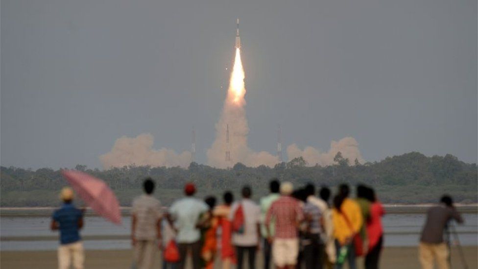 In this file photo taken on March 29, 2018, shows Indian onlookers watching as the Indian Space Research Organisation"s (ISRO) GSAT-6A communications satellite launches on the Geosynchronous Satellite Launch Vehicle (GSLV-F08) from Sriharikota