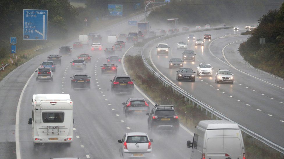 Cars make their way along the M4 motorway near to junction 18, as heavy rain lashes the UK