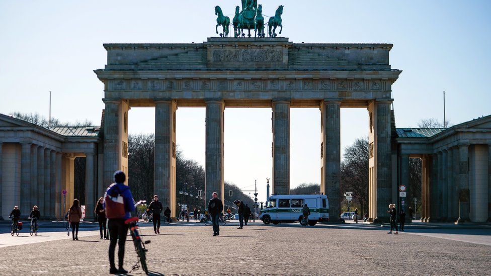 A police car drives in front of the Pariser Platz square in front of the Brandenburg Gate in Berlin