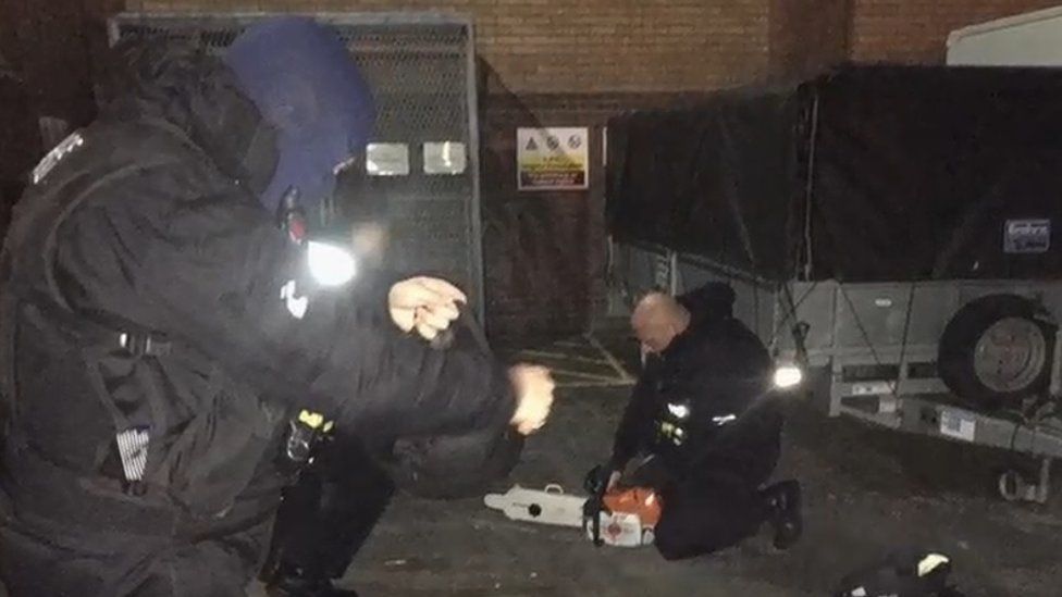 Police officers with chainsaw