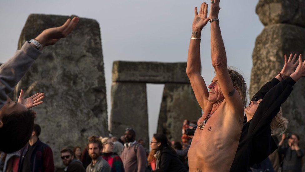 Revellers practice yoga as the sun rises and = they celebrate the pagan festival of Summer Solstice at Stonehenge in Wiltshire, southern England on June 21, 2017.