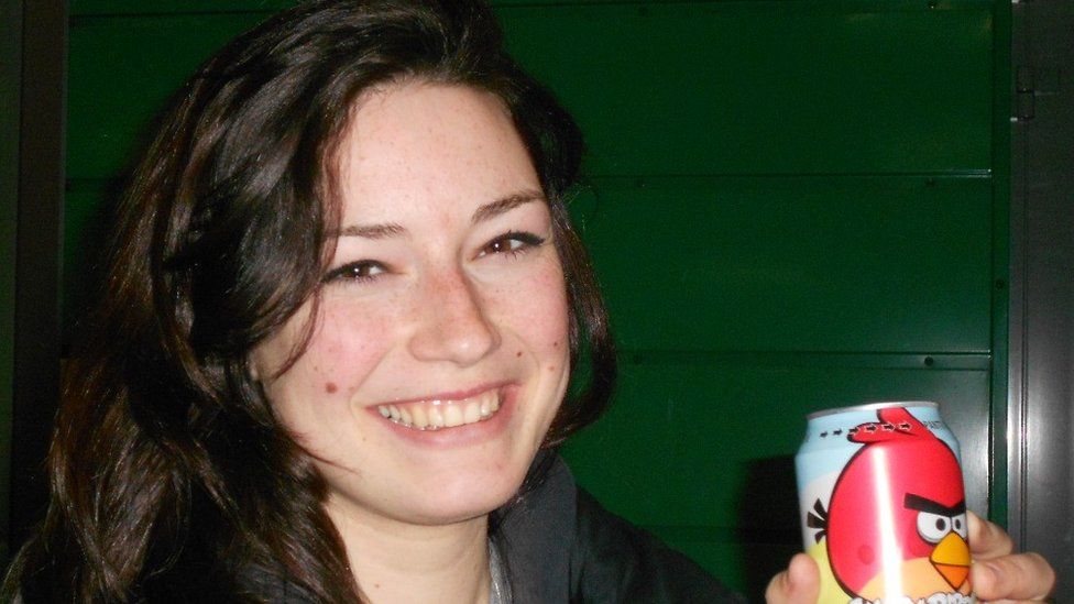Ellie Rowe smiling holding a beer can with a bird on it