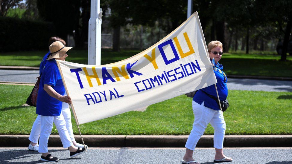 Women hold a banner thanking the Royal Commission into institutional child sexual abuse