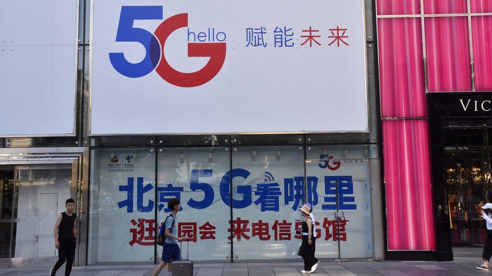 People walk past a China Telecom 5G advertisement on July 25, 2019 in Beijing, China