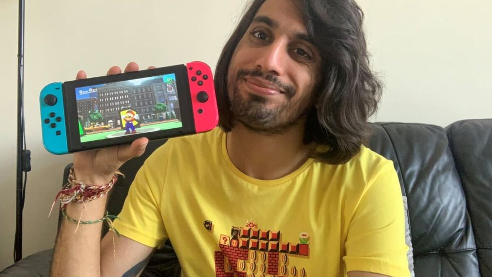 Vaneet wearing a Nintendo t-shirt and holding a Nintendo Switch