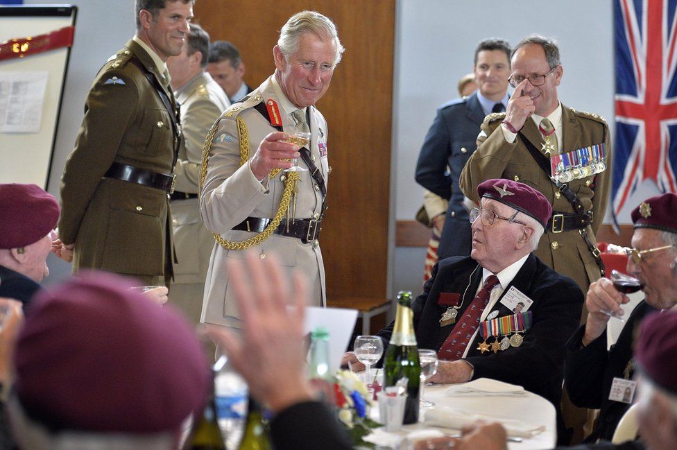 Prince of Wales (centre) raising his glass to D-Day veterans