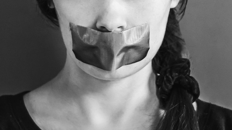Woman with mouth taped over