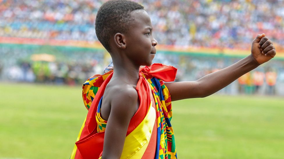A boy in traditional dress marching during independence celebrations in Kumasi, Ghana - Friday 6 March 2020