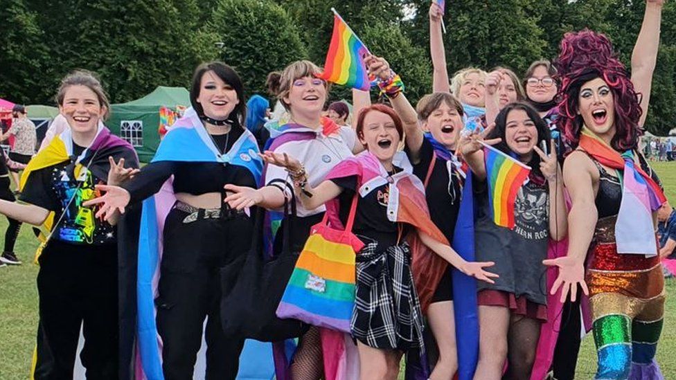 Aida H Dee in drag with others holding pride flags