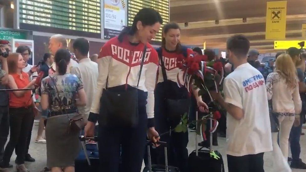 Russian athletes are greeted as they head to Rio Olympics