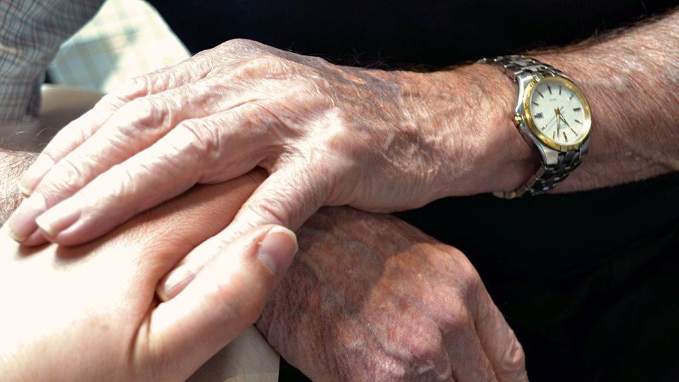 A generic photo of elderly hands holding younger hands