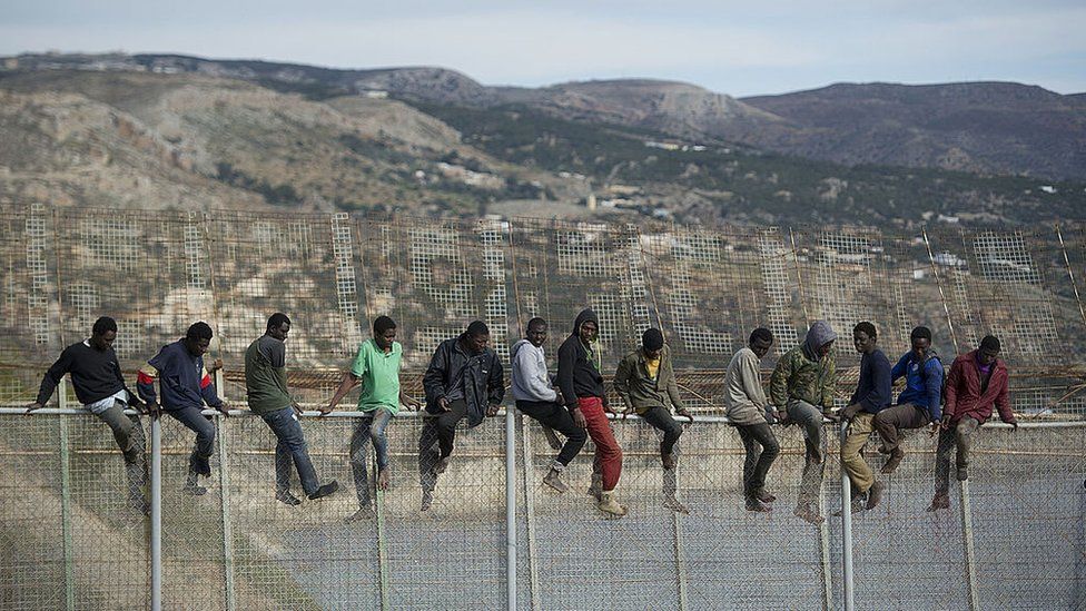 African migrants attempt to scale the fence at the border between Morocco and the North African Spanish enclave of Melilla