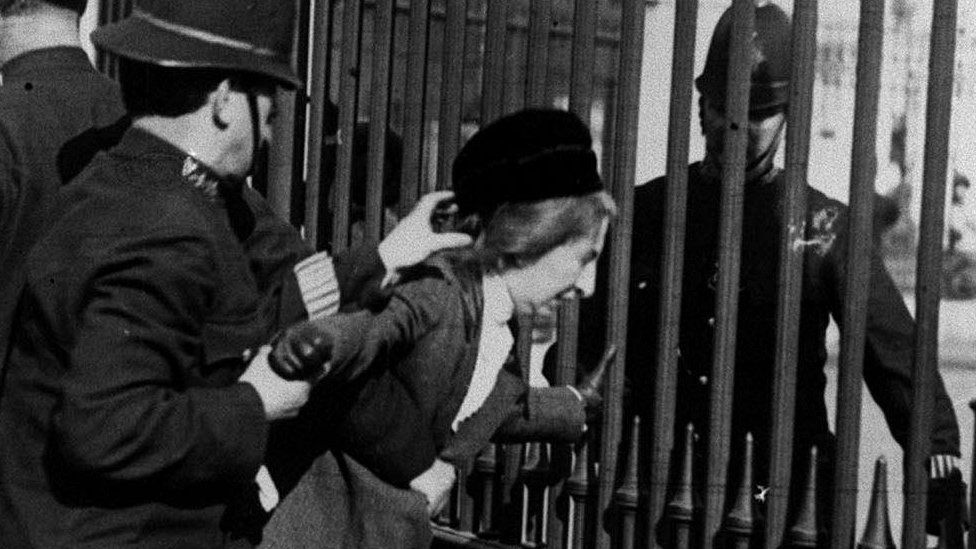 A Suffragette being arrested by police officers during a protest outside Buckingham Palace in 1914