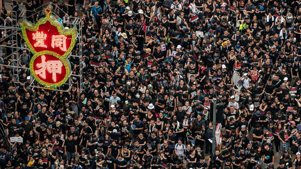 Protesters hold banners and shout slogans as they march on a street on June 16, 2019 in Hong Kong