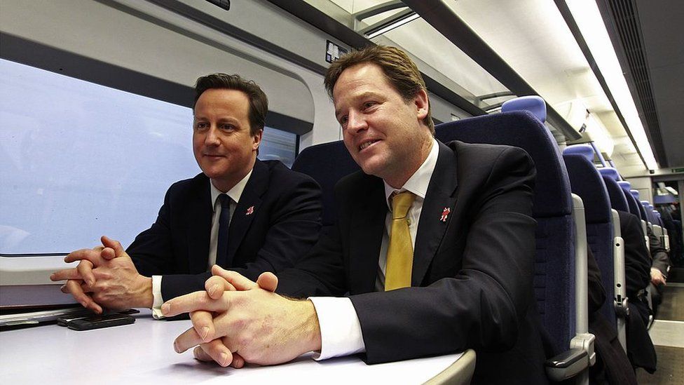 Britain's Prime Minister David Cameron (L) and Deputy Prime Minister Nick Clegg ride a train to a cabinet meeting at the 2012 Olympic Games site on January 9, 2012 in London, England.
