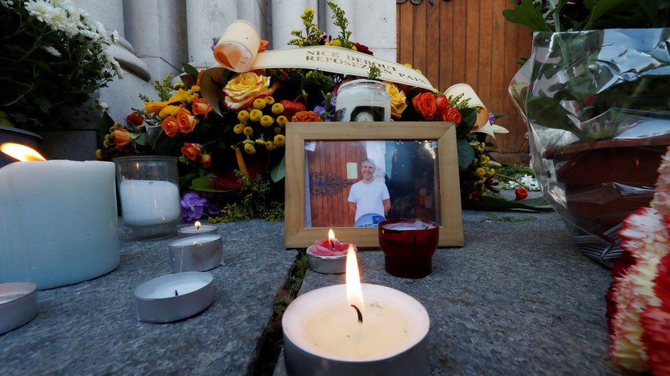 A picture of Vincent Loques, sexton of the Notre Dame church, one of the victims of a deadly knife attack, is seen with candles and flowers in front of the Notre Dame church in Nice, France, October 30, 2020.