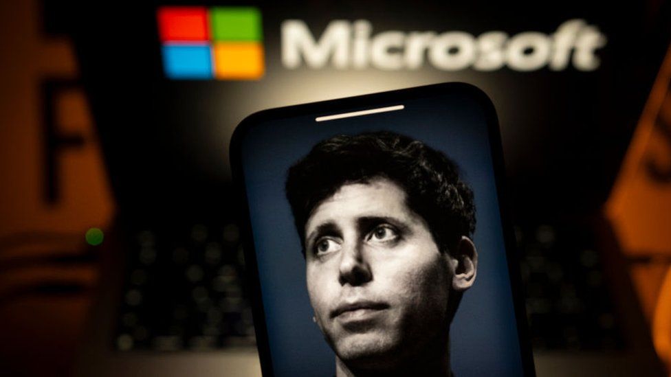 Picture of Sam Altman in front of a Microsoft logo