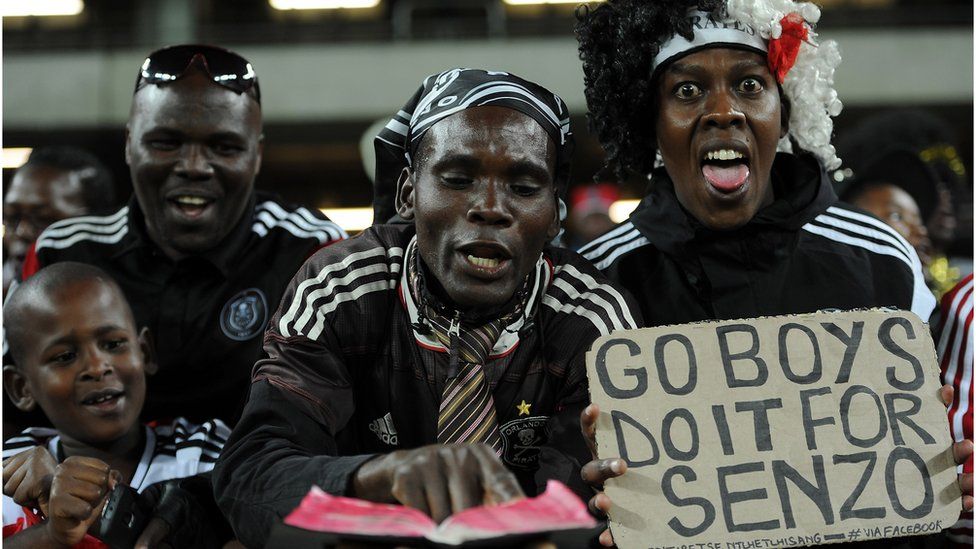 Supporters of South Africa's Orlando Pirates cheer before the first final of the 2015 CAF - Confederation of African Football Cup match with Tunisian Etoile du Sahel on 21 November 21, 2015 in Johannesburg.